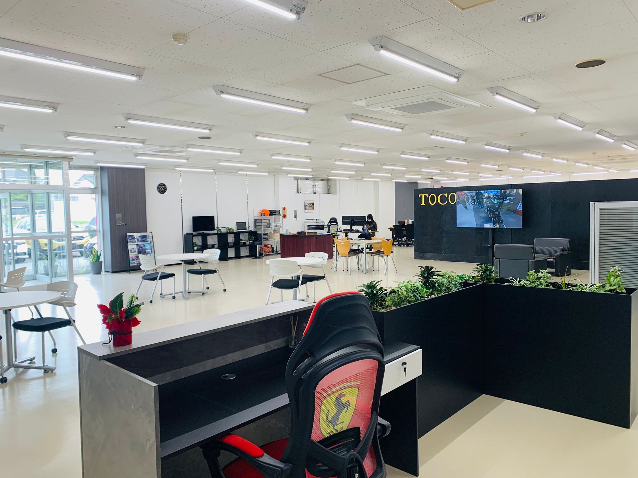 Office floor with reception, meeting tables, and the dispatch desk.